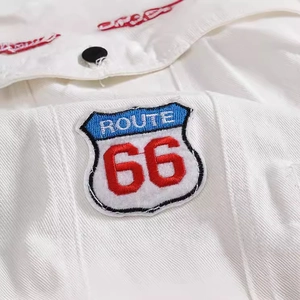 White denim vest featuring a vintage Route 66 shield embroidery and black button detail