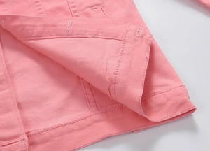 Detailed macro view of the hem and interior stitching on a pink denim jacket