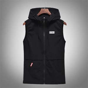 Detail of hooded black vest featuring a white COOL patch and red pocket label accents