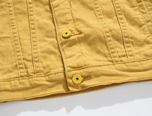 Detail of yellow denim jacket showing high-quality stitching and metal JEANS buttons