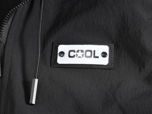 Detailed macro view of the black vest fabric with a COOL patch and metallic drawstring tips