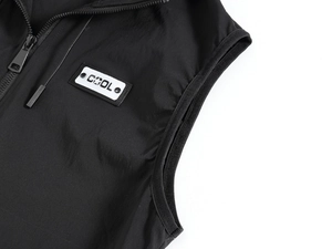Detail of black vest showing woven texture, COOL patch and metallic zipper structure