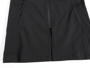 Detail view of the black zip-up vest featuring durable ripstop fabric and side pockets