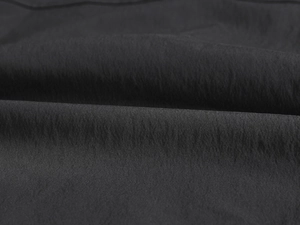 Macro detail of high-density black synthetic fabric with micro-texture for men's vest
