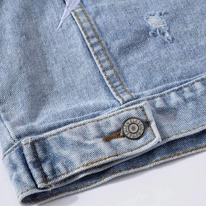 Men's light blue denim vest detail with classic metal button and distressed ripped texture