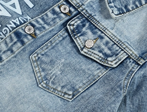 Detail of vintage washed blue denim jacket with flap pocket and engraved metal button
