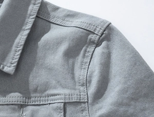 Detail of grey denim jacket collar showing durable double stitching and twill fabric
