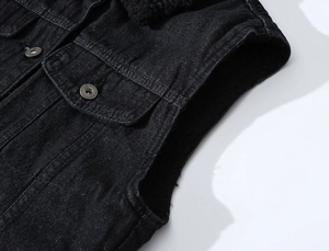 Détail de gilet en jean noir montrant le col en polaire et boutons métalliques gravés