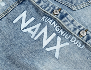 Men's light blue washed denim jacket featuring white letter print and metal buttons