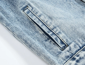 Detail of light blue washed denim jacket featuring contrast stitching and a welt pocket