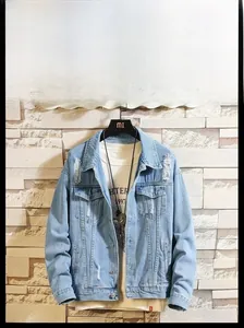 Detail of light blue denim jacket with distressed textures and classic turn-down collar