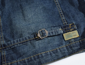 Vue macro de la texture denim avec boucle en métal réglable et écusson en cuir du logo