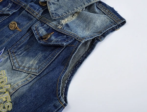 Detailed macro of vintage washed denim vest with embroidery and metal buttons