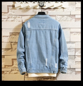 Rear view of light blue denim jacket with distressed ripped details and washed texture