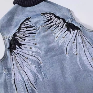 Men's light blue denim vest featuring embroidered wings and silver metal studs on back