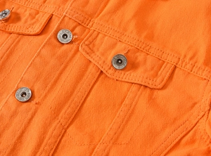 Detailansicht der orangefarbenen Denim-Jacke mit Metallknöpfen und Workwear-Taschen