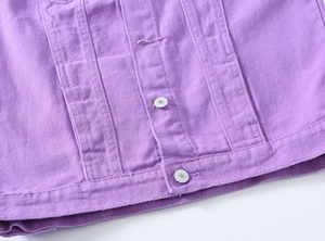 Gros plan détaillé sur le tissu denim violet avec boutons métalliques et coutures renforcées