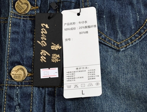Gros plan de l'étiquette d'un gilet en jean indiquant 80% coton et détails de taille L