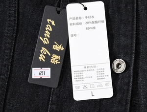 Detail view of denim vest tag showing 80% cotton material and metal button