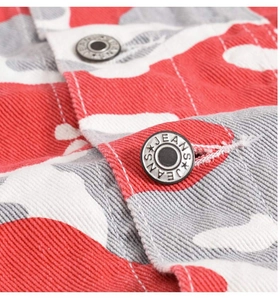 Macro shot of red camo denim jacket detailing with branded metal button and twill texture