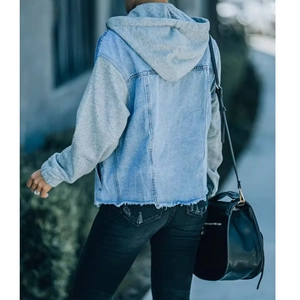 Detail of the oversized patchwork denim jacket with grey knit hood and raw hem texture