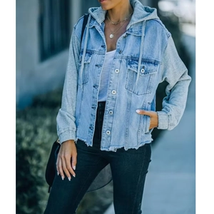 Detail of loose-fit denim jacket featuring gray knit sleeves and raw hem craftsmanship