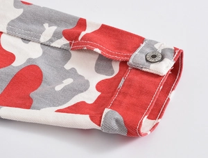 Detail of red camouflage denim jacket sleeve with silver JEANS button and twill texture