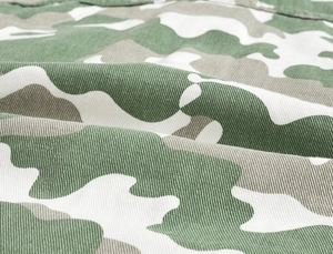 Close-up of green camouflage twill fabric with detailed stitching for men's jacket