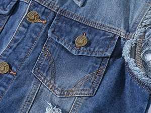 Detail showing blue denim fabric with orange stitching and vintage metal buttons