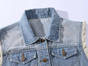 Close-up of denim vest collar with distressed frayed edges and antique metal buttons