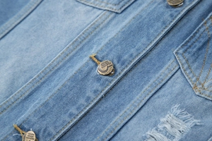 Détails de la veste en jean bleu clair avec boutons en laiton et coutures jaunes