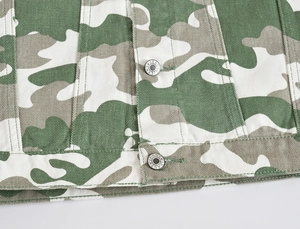Close-up of military camouflage denim jacket with detailed metal JEANS button
