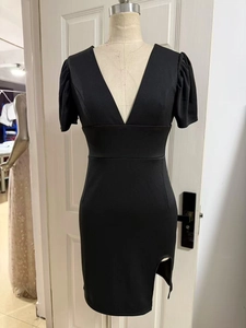 Detail of black V-neck dress with puff sleeves and side slit on a mannequin stand