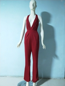 Macro detail of high-waist pleated bodice on deep red halter neck jumpsuit