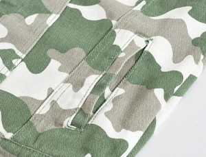 Detail of green camo jacket featuring twill cotton fabric and double-stitched welt pocket
