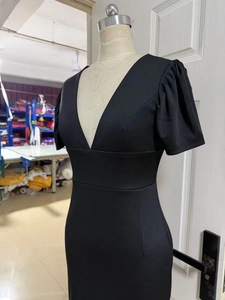 Detail of a black bodycon dress featuring a deep V-neck and puff sleeves on a white mannequin