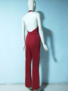 Back view of a red halter neck jumpsuit featuring an open back and wide leg trousers