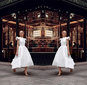 Detail of white midi dress featuring elegant ruffle sleeves and high-waisted satin flare skirt