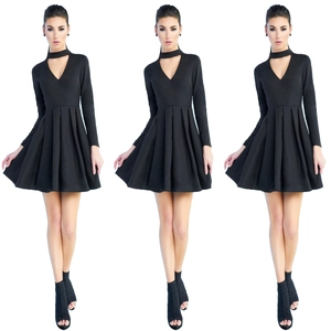 Détail de robe noire à manches longues avec décolleté en V, choker et jupe plissée