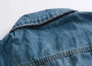 Detail of the classic blue denim vest showing the collar and orange stitching craftsmanship