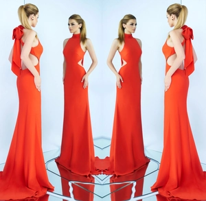 Dettaglio dell'abito da sera rosso con scollo all'americana, tagli e fiocco sul retro