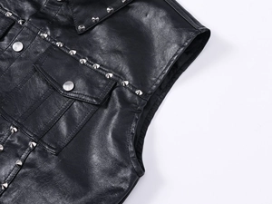 Close-up of punk style black leather vest with metal rivets and lychee texture details