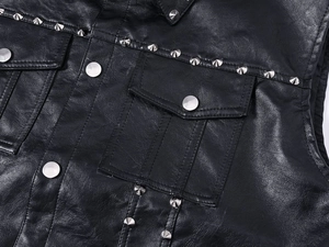 Detail of black leather vest featuring silver cone studs and reinforced double stitching