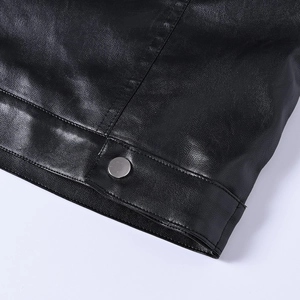 Detailed close-up of premium black leather texture with silver metal snap buttons and neat stitching