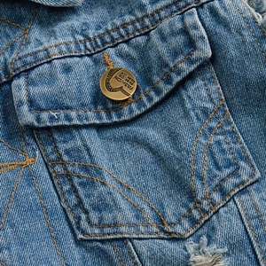 Men's slim fit distressed blue denim vest featuring flap pockets and copper buttons