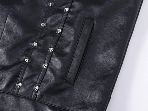 Detail of black leather vest featuring silver cone studs and fine welt pocket stitching