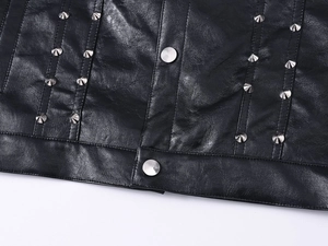 Close-up of black leather vest featuring silver cone studs and metal buckle detail