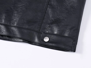 Detailed close-up of men's leather vest hem showing lychee texture and silver metal button