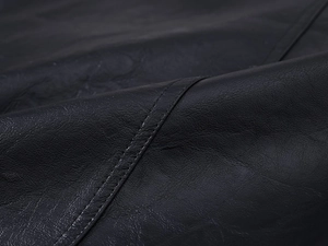 Macro shot of high-quality black leather texture with detailed stitching and soft grain