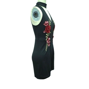 Detail view of vivid red rose floral embroidery on black V-neck halter romper